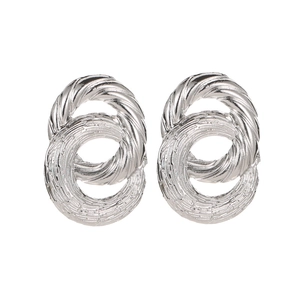 Close-up of silver-tone figure-eight twisted earrings with detailed woven texture