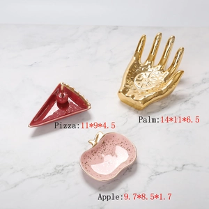 Ceramic jewelry tray set with pizza, palm, and apple shapes on marble background
