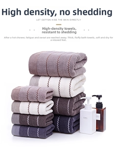 Close-up of thick absorbent cotton towels stacked in purple, white, brown and blue