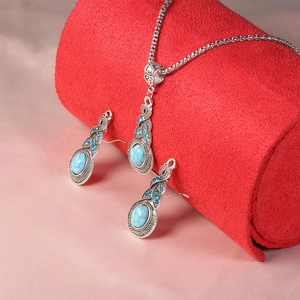 Set gioielli vintage con pendenti turchesi e cristalli blu su espositore in velluto