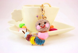 Detail of pink crystal caterpillar keychain with colorful rhinestones on a gold alloy ring