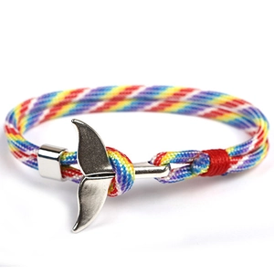 Close-up of rainbow braided paracord bracelet with a silver whale tail metal buckle clasp