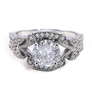 Macro view of vintage style silver engagement ring with milgrain leaf design and central diamond