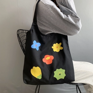 Borsa tote in tela nera con stampe floreali colorate e comoda tracolla larga da donna