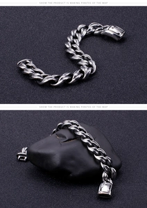 Detailed view of polished stainless steel Cuban link bracelet with rectangle clasp on stone