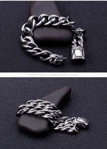 Close-up of heavy stainless steel cuban chain bracelet with square clasp on stones