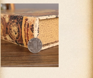 Dettaglio macro della scatola a libro decorativa mappa del mondo con moneta