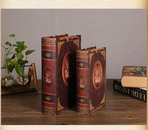 Dettaglio di scatole a forma di libri vintage con fregi dorati e trama in pelle