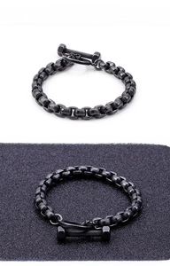 Macro shot of matte black dumbbell toggle clasp and textured chain link bracelet