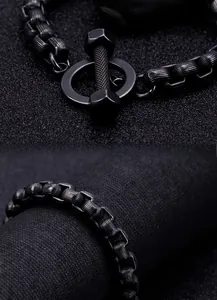Detail of matte black men's dumbbell chain bracelet with textured links and toggle clasp