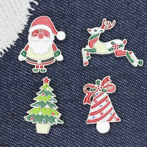 Detailed view of four festive Christmas pins on denim, including Santa and reindeer