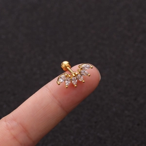 Macro view of gold ear stud with five marquise-cut zircons displayed on a fingertip