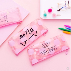 Pink transparent PVC cat pencil case with Meow print and stationery on a desk