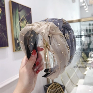 Detail of beige and blue double knotted headbands with sparkling rhinestones and mesh