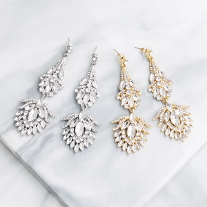 Detail view of vintage long drop earrings with rhinestones in gold and silver finish