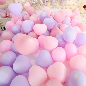Romantic pink and purple heart balloons on a bed with LOVE letter decoration for party
