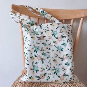 Detailed close-up of a floral cotton canvas tote bag hanging on a wooden chair