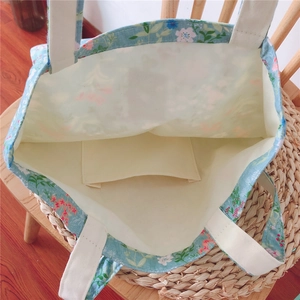 Detailed interior of floral canvas tote bag featuring inner pocket and beige strap