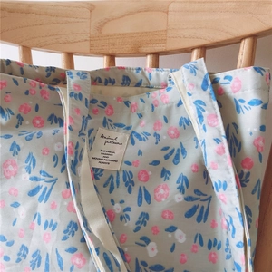 Detailed close-up of a floral cotton tote bag with a pink flower pattern and canvas tag