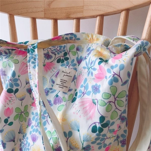 Detail of floral canvas tote bag hanging on wooden chair with high quality texture view
