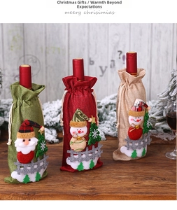 Detailed view of linen Christmas wine bottle covers with Santa and snowman embroidery