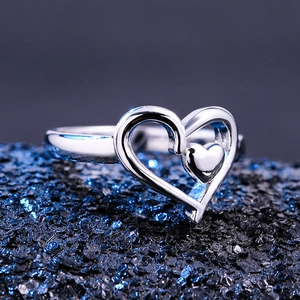 Polished silver double heart ring featuring a hollow outer and solid inner heart design