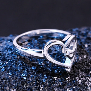 Silver-colored double heart ring with hollow and solid nested design on a starry backdrop