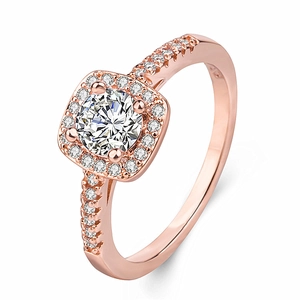 Rose gold engagement ring with round center diamond and halo setting on a white background