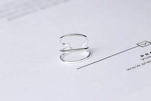 Macro detail of minimalist S925 sterling silver triple-layer ear cuff earring