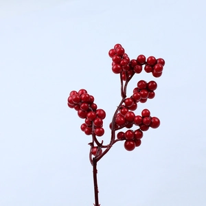 Detailed view of artificial red berry branches with glossy finish for festive home decor