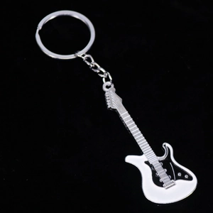Detalle de un llavero de guitarra eléctrica creativo en blanco y negro sobre fondo oscuro