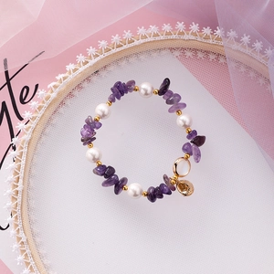 Detail of beach style elastic bracelet with purple amethyst, pearls and shell charms