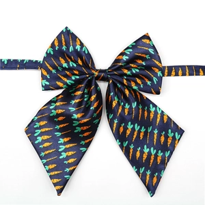 Close-up of navy blue dog bowtie with carrot pattern and adjustable strap detail