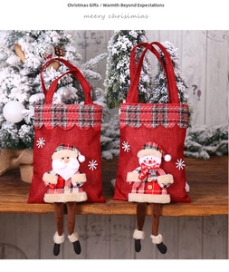 Détail du sac cadeau de Noël en lin avec poupées Père Noël et bonhomme de neige en carreaux