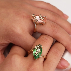 Golden dragonfly ring set featuring olive green and pink marquise stones on model's hand