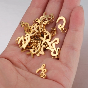 Golden stainless steel cursive number pendants for jewelry making held in a palm