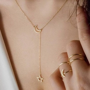 Detail of gold-plated leaf necklace and crescent moon pendant set on female model