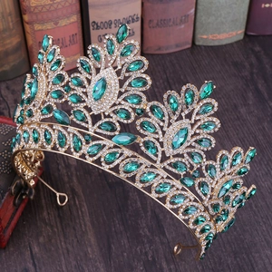 Dettaglio corona da sposa barocca con gemme verdi e strass su superficie in legno