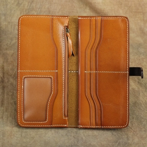 Dettaglio portafoglio lungo in pelle marrone vintage con scomparti carte e zip