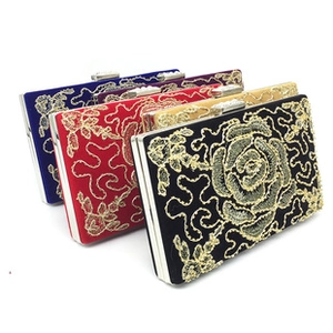 Detailed view of luxury velvet evening clutch bags with golden floral embroidery and metal clasp