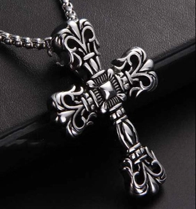 Macro shot of vintage style metal cross pendant with intricate floral engravings