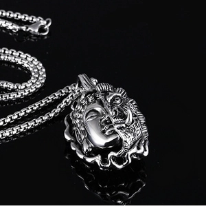 Detail of silver double-sided pendant with Buddha and demon faces on box chain
