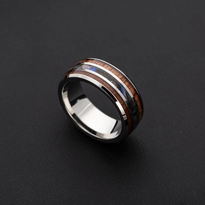 Detail of titanium steel ring with wood grain inlay and abalone shell finish
