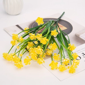 Detail of small yellow artificial flowers with dense petals and green plastic stems