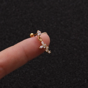Macro detail of gold-plated starfish stud with cubic zirconia held on a fingertip