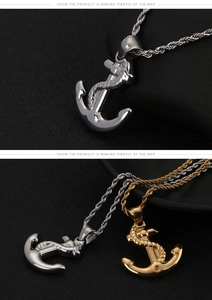 Close-up of gold and silver anchor pendant necklaces with rope detail on black background