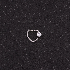 Detailed view of silver heart-shaped nose ring with a micro-inlaid zircon on black background