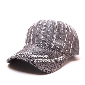 Dettaglio di un cappello da baseball da donna in maglia grigia con strass scintillanti.