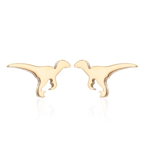 Macro view of gold dinosaur stud earrings showing detailed velociraptor silhouette