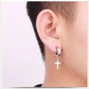 Close-up of model wearing silver stainless steel hoop earrings with cross pendant